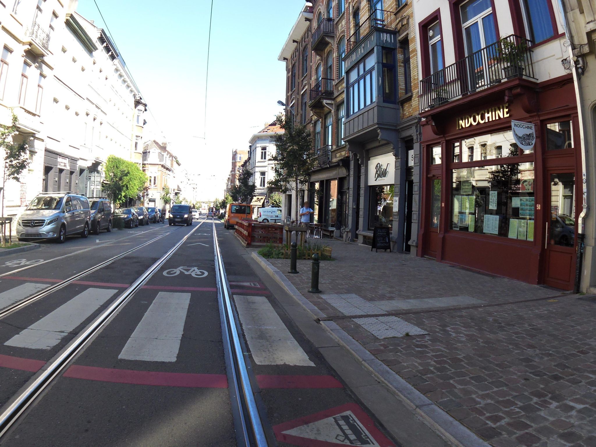 Rue bruxelloise avec rails de tram et piste cyclable au sol